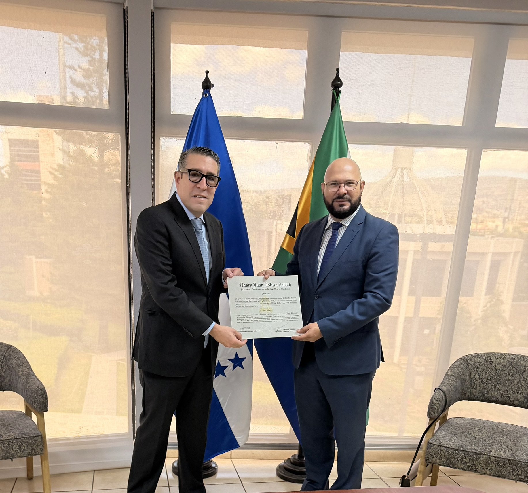 El Cónsul Honorario José Benjamín Membreño Marchetti recibe sus credenciales junto a las banderas de Honduras y Sudáfrica.
